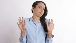 woman with hands up looking away in disgust